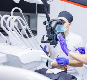 Imagem ilustrativa do Dentista do sistema dentista 24 horas e agendamento, utilizando um microscópio odontológico de última geração durante um procedimento de urgência e emergência. O uso da tecnologia de magnificação proporciona mais precisão e qualidade no tratamento.